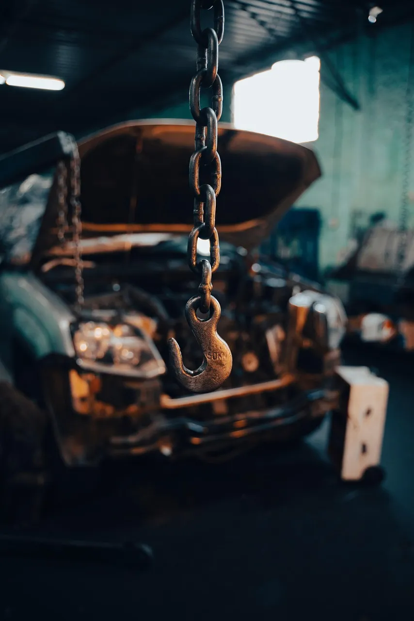 Engine suspended on a hoist in a workshop